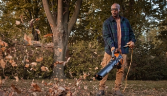 Man using a leaf blower outdoors.