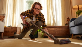 Man vacuuming floor in home.