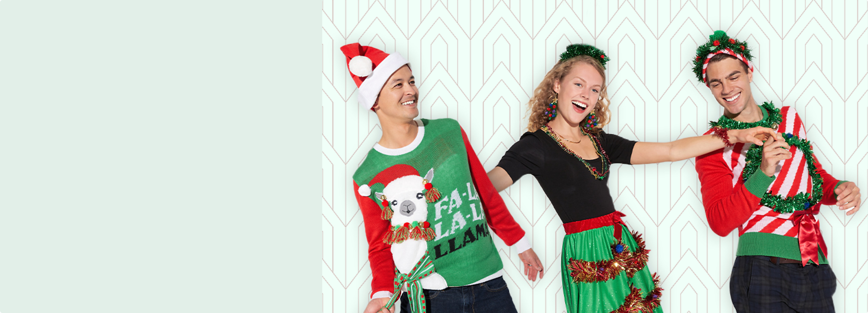 Two men and a woman posing together wearing Christmas themed sweaters and accessories including a red felt Santa hat.