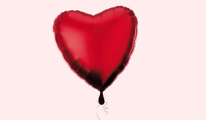 A red heart foil balloon with a white curled ribbon.