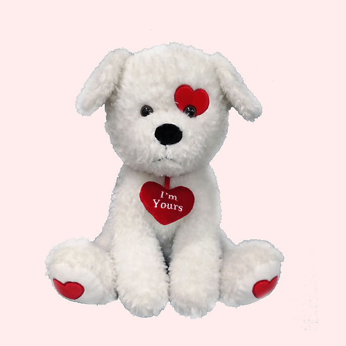 A white plush dog toy with red heart accents including a heart around its neck that reads “I’m Yours” in white text.