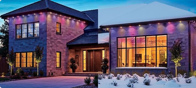 A modern home decorated with customizable multicolour smart Christmas lights along the roofline and exterior walls in a snowy setting.