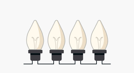Four warm white Christmas light bulbs with black bases.