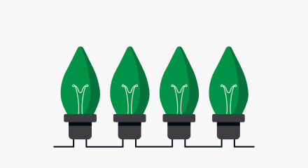Four green Christmas light bulbs with black bases.