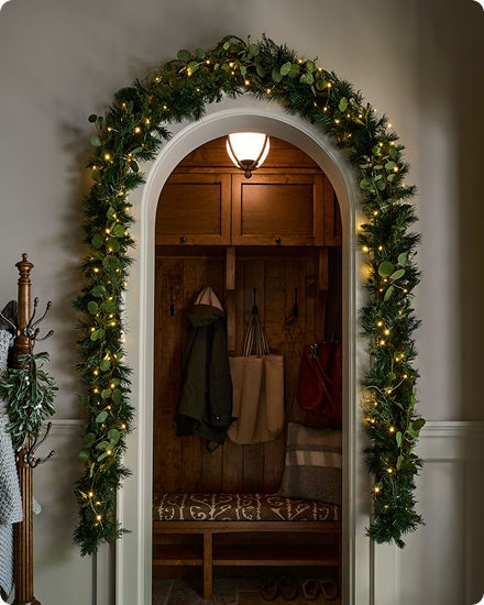 Illuminated garland wrapped around an indoor archway with warm white fairy lights.