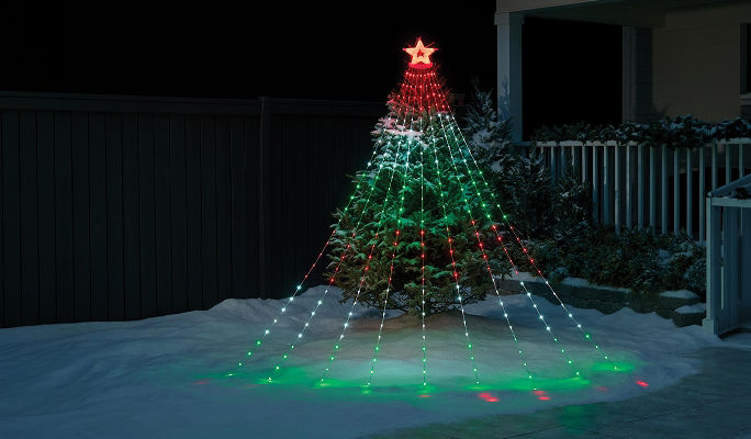 NOMA Smart Shooting Star Tree Light displayed in a snow-covered yard, creating a Christmas tree-shaped light display with multicoloured lights and a star topper designed for customizable effects and music synchronization.